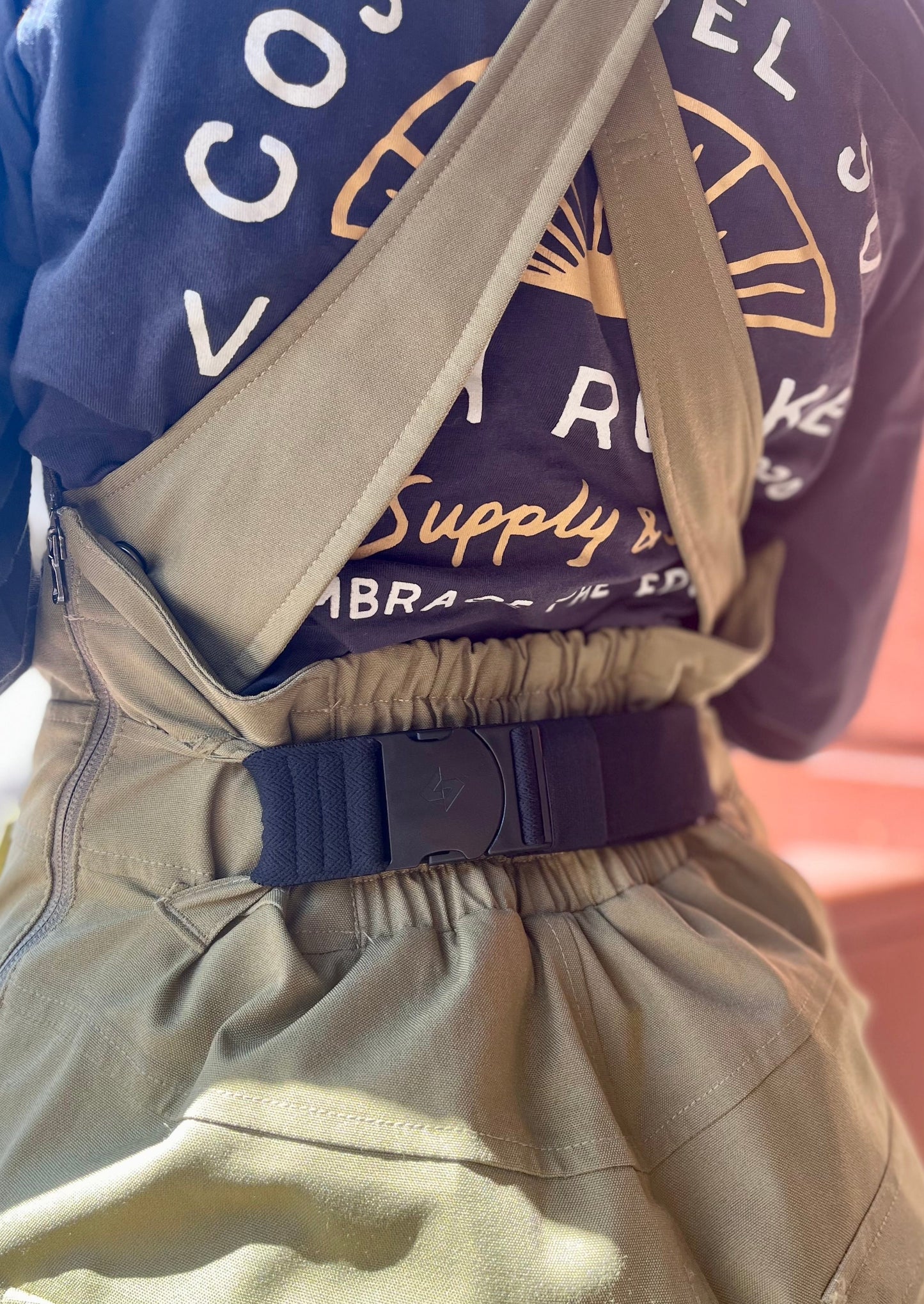 girl wearing a green Burton bib with a black bib belt