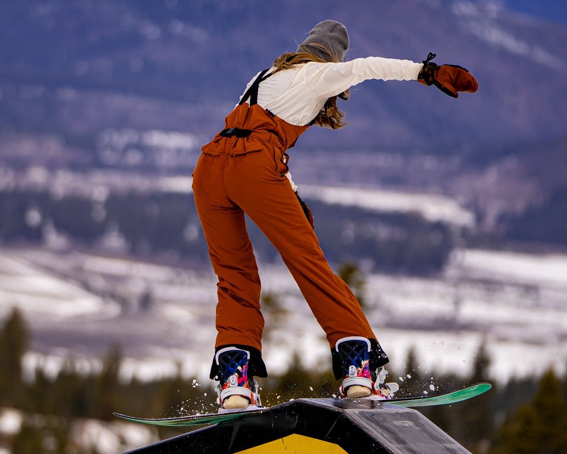 Bib belt on girl snowboarding in park